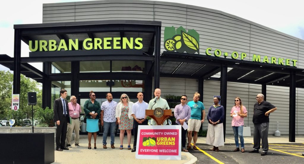 board and community officials outside the co-op