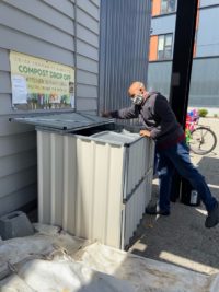 Man opening the compost bins to drop off kitchen scraps