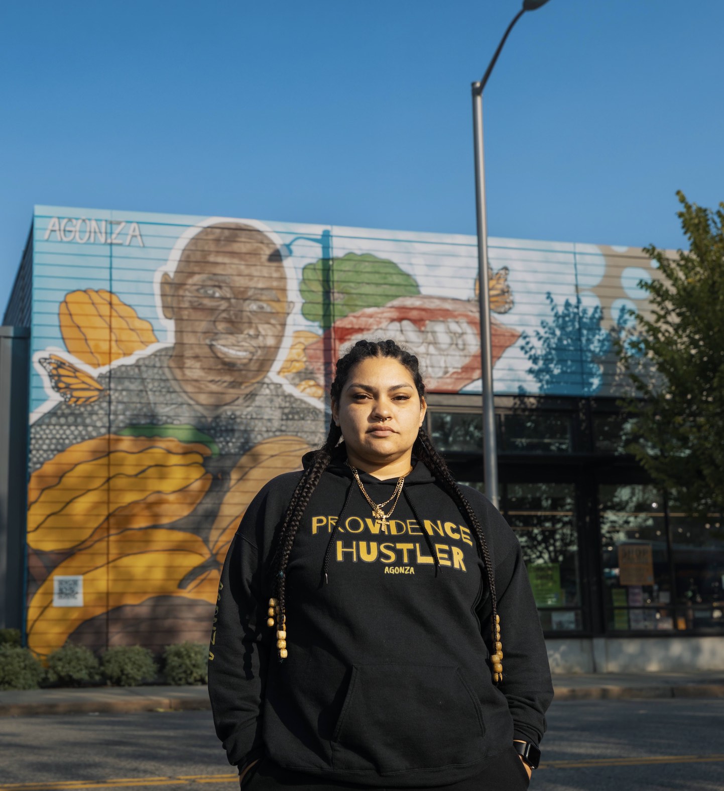 Artist AGONZA in front of her mural